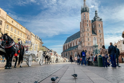 rynek w Krakowie. Widok na kościół mariacki, na płycie rynku dorożki, mieszkańcy miasta i turyści