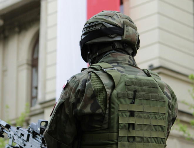 żołnierz z bronią z polską flagą w tle