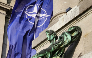 posąg z flagą NATO w tle