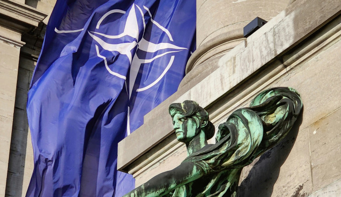 posąg z flagą NATO w tle