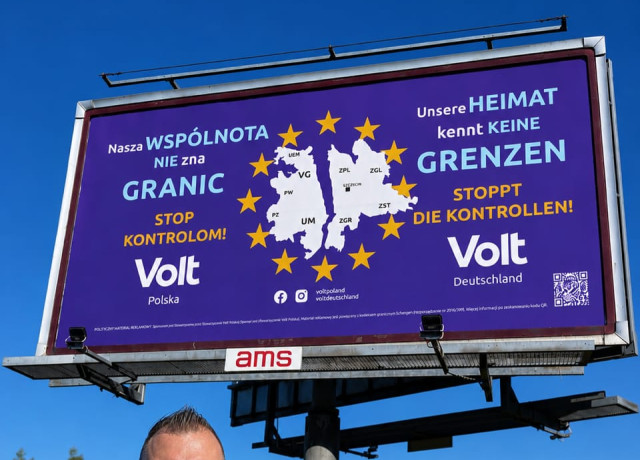 członek volt polska Denny na tle billboardu Volt mówiącego 